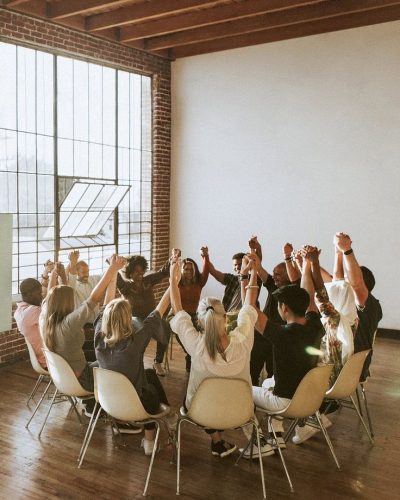 Group of diverse people holding hands up in the air